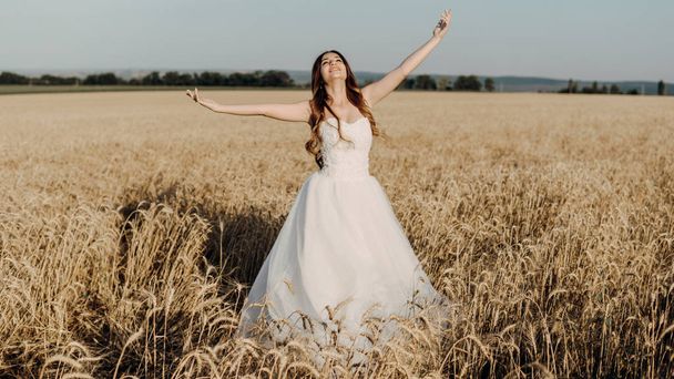 Krásná nevěsta v pšeničném poli při západu slunce - Fotografie, Obrázek