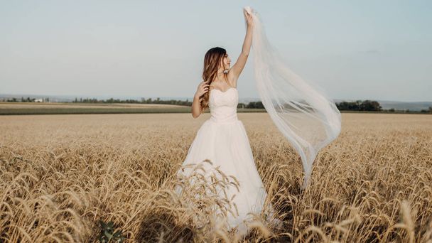Krásná nevěsta v pšeničném poli při západu slunce - Fotografie, Obrázek