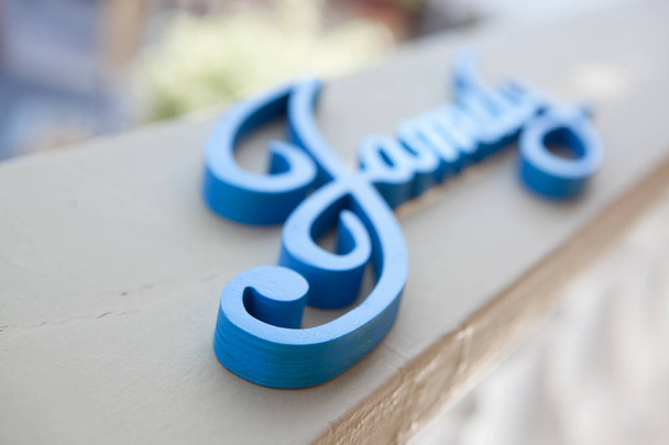Close-up palavra de madeira família azul em uma superfície leve, foco suave
 - Foto, Imagem