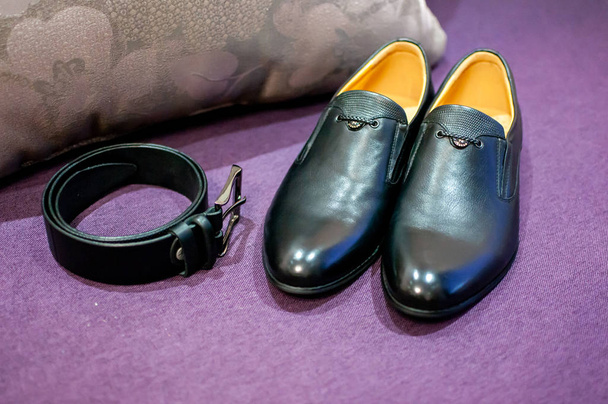 faixa preta e sapatos pretos no sofá roxo
 - Foto, Imagem