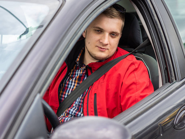Νέος οδηγός αυτοκινήτου σε ένα κόκκινο μπουφάν - Φωτογραφία, εικόνα