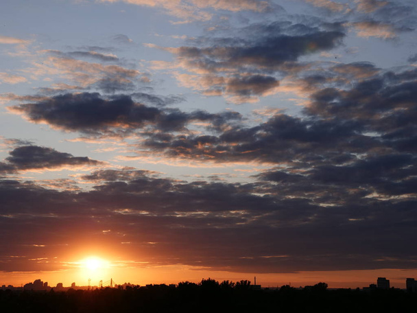 Dramaattinen värikäs auringonlasku punainen kuuma aurinko yli Kiovan kaupungin
. - Valokuva, kuva