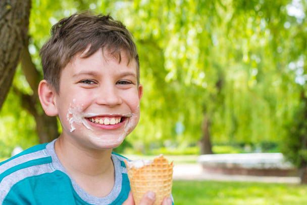 teen boy w parku jedzenia lody - Zdjęcie, obraz