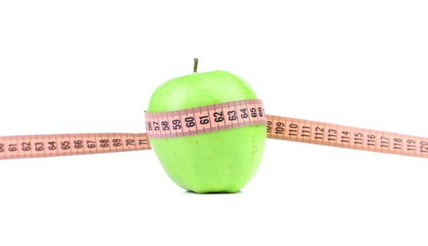 Green apple with measuring tape. White background. - Фото, зображення