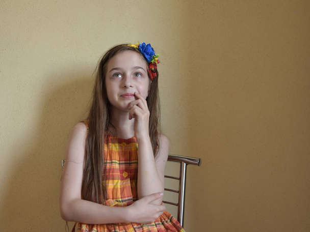 Маленькая девочка с седыми глазами и светлыми волосами сидит на стуле
 - Фото, изображение
