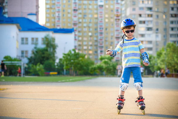 Маленький хлопчик катається на роликах влітку в парку. Щасливий ч
 - Фото, зображення