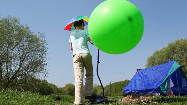 Boy pumps rubber ball, little girl goes inside tent - Footage, Video