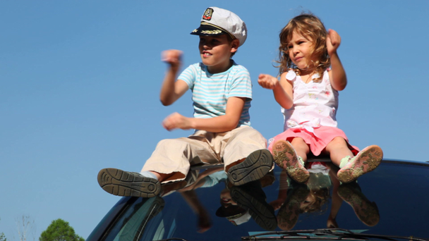 Fiú és annak lánytestvérének ül-ra tető-ból autó - Felvétel, videó