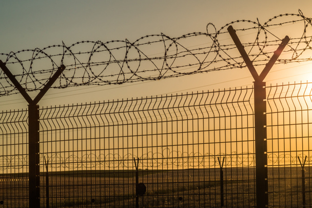 ostnatý drát ocelová stěna proti přistěhovalectví - Fotografie, Obrázek