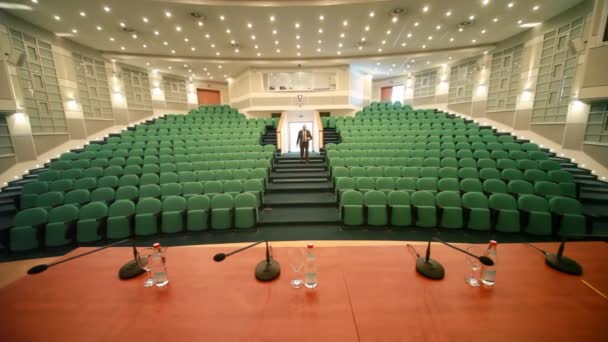 One man comes into empty conference hall - Video