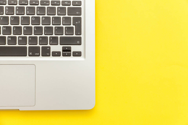 Клавиатурный ноутбук изолирован на желтом фоне стола. Современные информационные технологии и программное обеспечение
 - Фото, изображение
