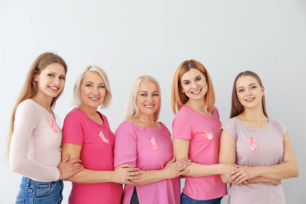 Kauniita eri-ikäisiä naisia vaaleanpunaisilla nauhoilla kevyellä taustalla. Rintasyövän käsite
 - Valokuva, kuva