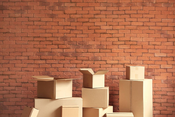 Cardboard boxes near brick wall - Photo, Image