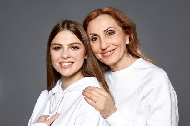 Portrét šťastné matky s dcerou na šedém pozadí - Fotografie, Obrázek
