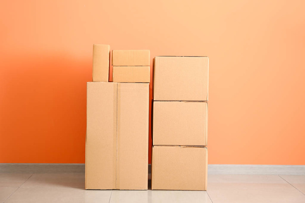 Cardboard boxes near color wall - Φωτογραφία, εικόνα