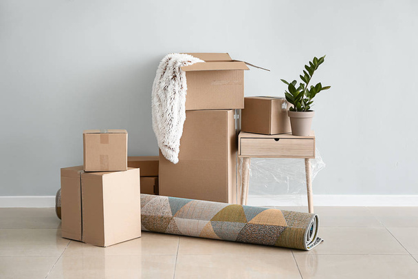 Boîtes en carton avec effets personnels prêtes à emménager dans une nouvelle maison près d'un mur léger
 - Photo, image