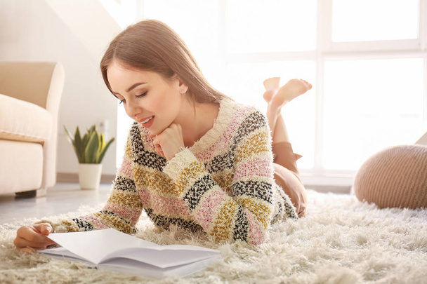 Красивая молодая женщина читает книгу дома - Фото, изображение