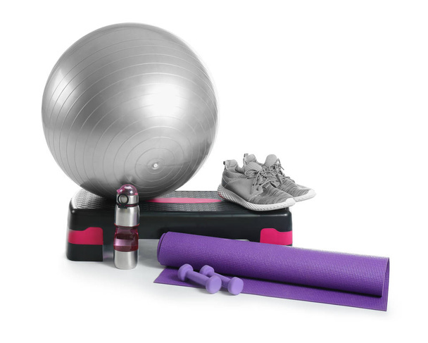 Set di attrezzature sportive con palla fitness, scarpe e bottiglia d'acqua su sfondo bianco
 - Foto, immagini