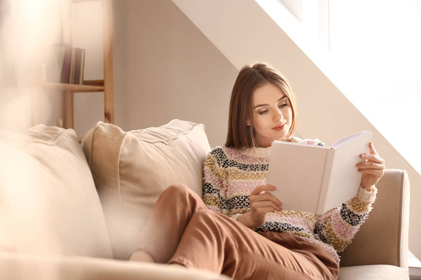 Belle jeune femme lecture livre à la maison - Photo, image