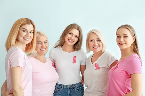 明るい背景にピンクのリボンを持つ異なる年齢の美しい女性。乳癌の概念 - 写真・画像