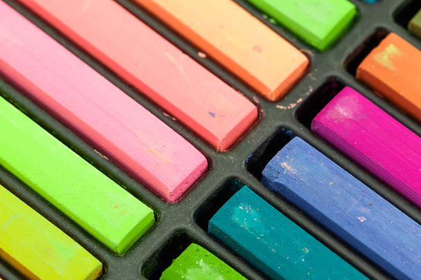 Close up Colorful chalks in a variety of colors arranged in tray - Photo, Image