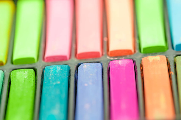 Close up Colorful chalks in a variety of colors arranged in tray - Photo, Image
