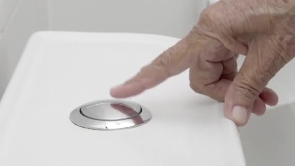 Elderly woman hand flushing toilet - Footage, Video