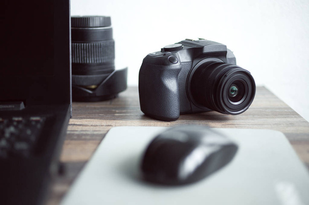 Photographe ou concept de photographie de stock, appareil photo numérique noir près d'un ordinateur portable sur un poste de travail de bureau
 - Photo, image
