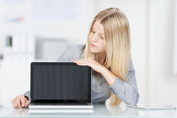 Blonde girl checks laptop screen - Фото, изображение