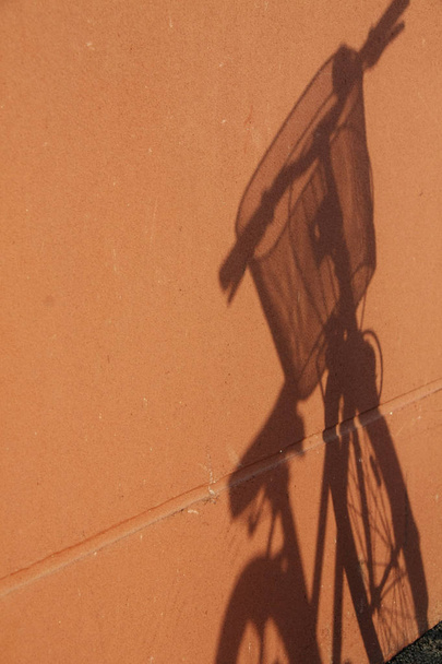 Shadow of bicycle on orange wall. - Foto, immagini