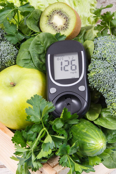 Glucometer for measuring sugar level and green fruits with vegetables. Diabetes, dieting and body detox concept - Foto, afbeelding