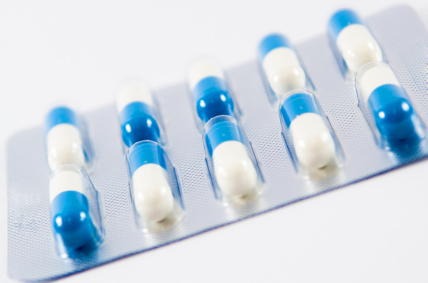 blauwe en witte capsule in transparante blister pack - Foto, afbeelding