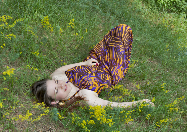 Pretty woman lying on the forest meadow - Foto, afbeelding