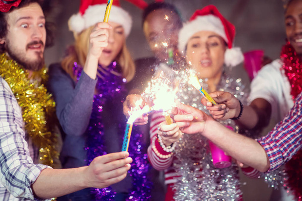 multiethnic group of casual business people lighting a sparkler - Foto, Imagem