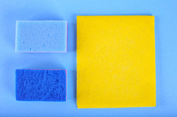 vista superior de las esponjas de limpieza sobre fondo azul
 - Foto, Imagen