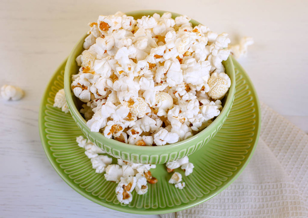 Close up of popcorn in green bowl. Good movie viewing - Photo, image