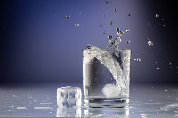Pouring water into glass on blue background close up - Zdjęcie, obraz