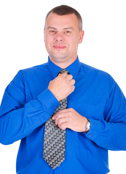 Retrato de hombre de negocios positivo, confiado y sonriente. El exitoso hombre de negocios con camisa azul endereza su corbata, fondo blanco aislado, concepto de liderazgo y éxito
 - Foto, imagen