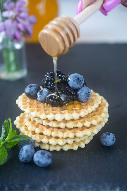 Crispy homemade round belgian waffles with berries and honey on top - Photo, Image