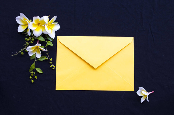 жовті квіти франгіпані місцева флора Азії з жовтим конвертом розташування плоский стиль листівки на фоні чорного
  - Фото, зображення