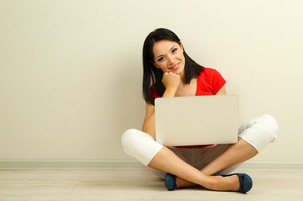 Beautiful young woman sitting with notebook in room - Foto, Imagem