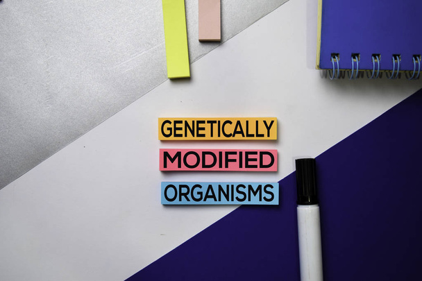 Organizmy zmodyfikowane genetycznie (GMO) tekst na kartkach samoprzylepnych z koncepcją kolorowego biurka - Zdjęcie, obraz