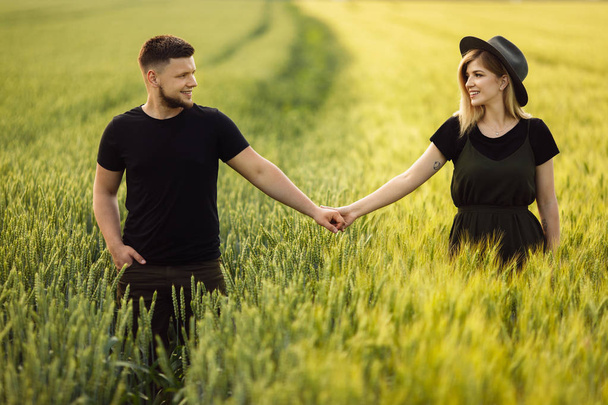 Beautiful young couple walking  on wheat field - Fotoğraf, Görsel