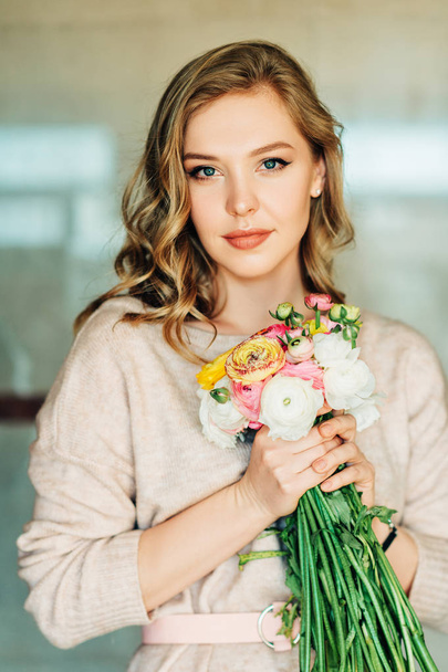 Portrait of beautiful young woman holding colorful buttercup flowers - Fotoğraf, Görsel