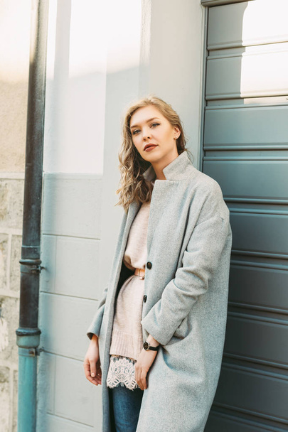 Retrato ao ar livre de bela jovem posando na rua, vestindo casaco cinza
 - Foto, Imagem