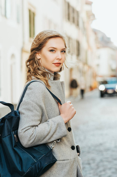 Portrait extérieur de belle jeune femme posant dans la rue, vêtue d'un manteau gris
 - Photo, image