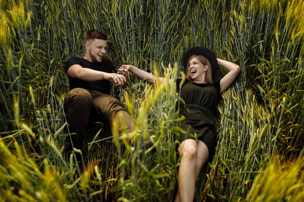 Beautiful young couple laying  in wheat field - Fotoğraf, Görsel