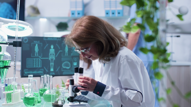 Chemist in research center studying some liquid samples - Video, Çekim