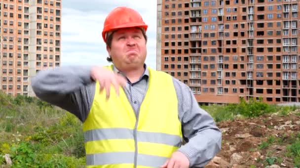 Male builder foreman, worker or architect on construction building site imitates work and manages construction - Felvétel, videó