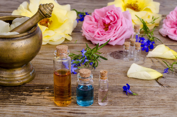 Bottle of essential oil for aromatherapy with fresh rose flowers. - 写真・画像